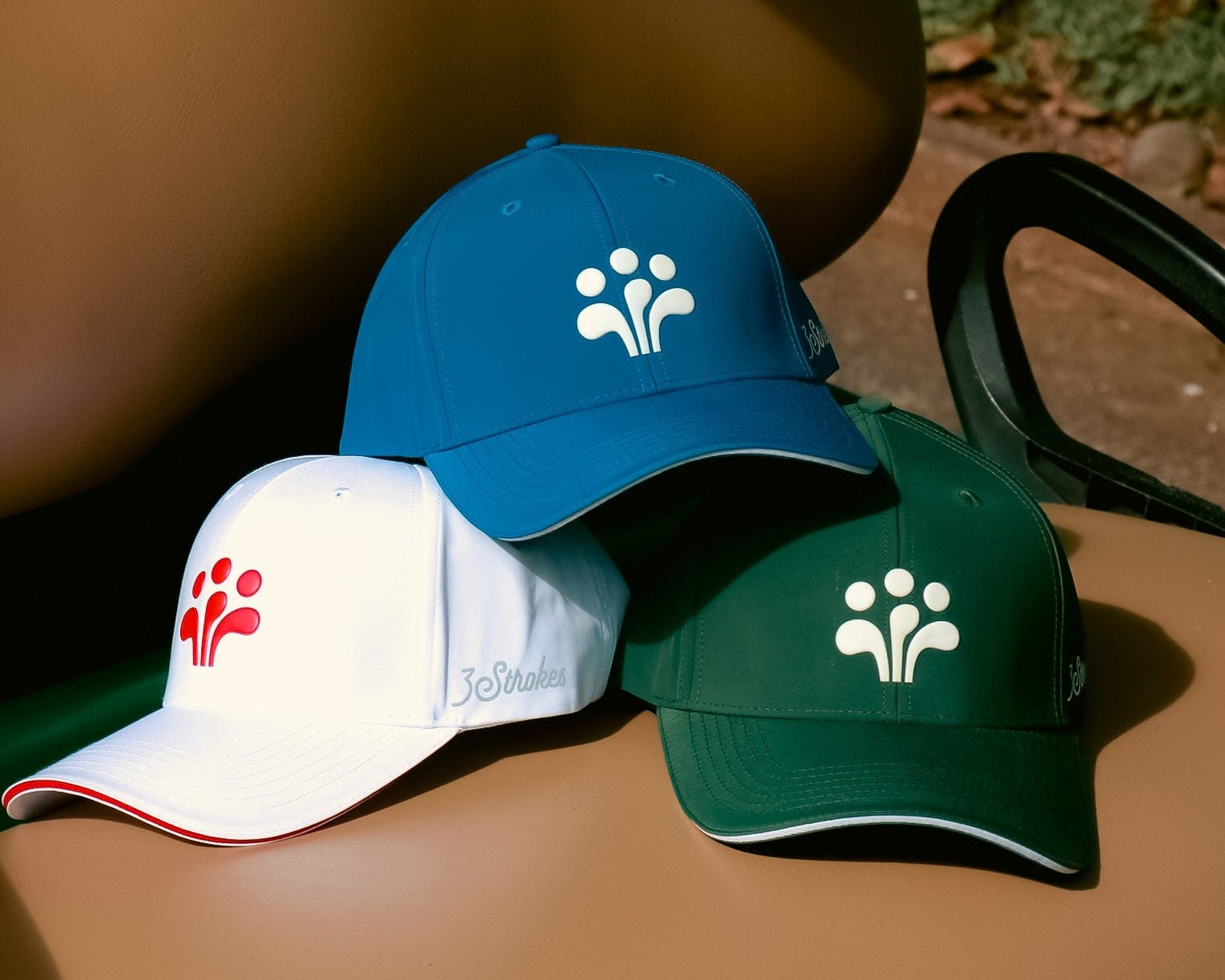 Three baseball caps with different logos on a brown surface.